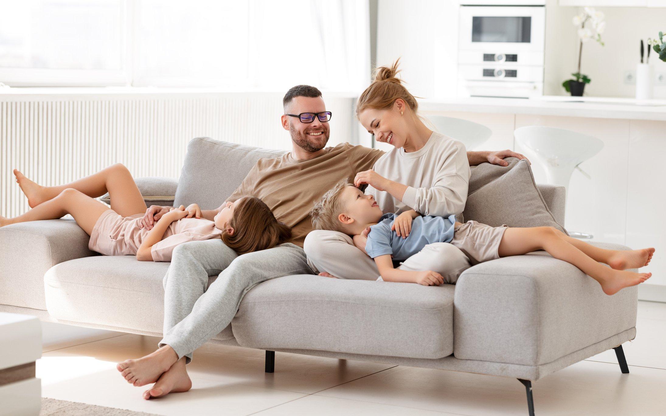 Family relaxing comfortably on sofa in bright home